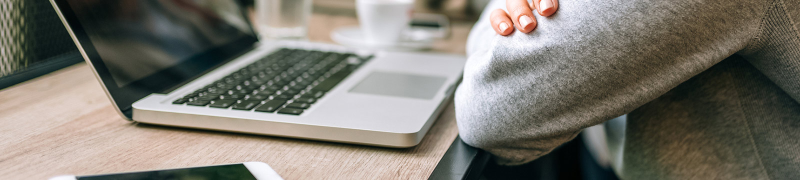 Person sitting at table in front of laptop